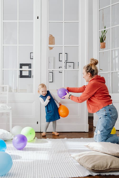 Mother and toddler playing with colorful balloons